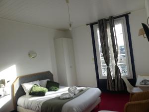 a bedroom with a bed and a large window at Le Renaissance in Montdidier