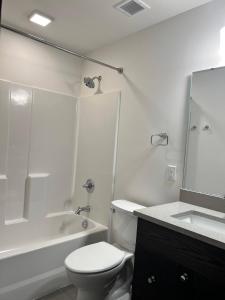 a white bathroom with a toilet and a sink at Brick & Bed Riverfront Lofts, T 410 in Saint Louis +18 photos
