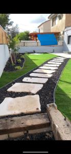 a garden with a walkway in front of a house at הבית של גיא בנאי in Beer Sheva