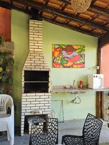 a fireplace in a patio with a painting on the wall at Flats Alto das Pedras in Trindade