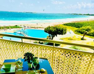 a balcony with a table and a view of the beach at Excellence Suites Orient Beach Oceanview King-Size Beach Pool Parking in Cul de Sac +187 photos