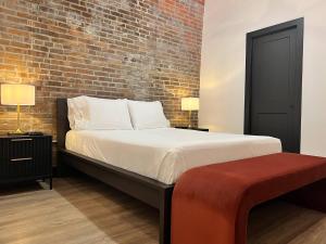 a bedroom with a bed and a brick wall at Brick & Bed Riverfront Lofts, T 410 in Saint Louis