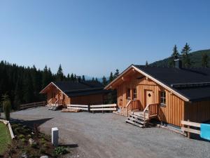 a row of wooden cabins in a parking lot at Holiday Home Jagdhütte by Interhome in Lachtal