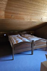a bed in a room with a wooden ceiling at Apartment Châlet Hochmatt by Interhome in Im Fang
