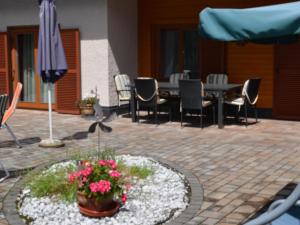 a patio with a table and chairs and an umbrella at Apartment Erna Angermaier by Interhome in Flattach