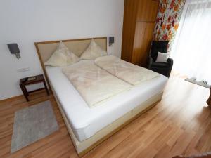 a bed with white sheets and pillows in a room at Apartment Erna Angermaier by Interhome in Flattach
