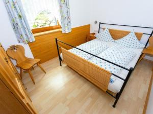 a bedroom with a bed and a chair and a window at Apartment Erna Angermaier by Interhome in Flattach +21 photos