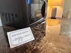 a sign sitting on a counter next to a microwave at The Crest Motel in Corona