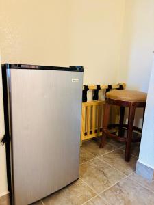 a small refrigerator in a room with a table at The Crest Motel in Corona +23 photos