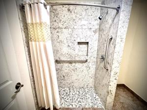 a bathroom with a shower with a shower curtain at The Crest Motel in Corona
