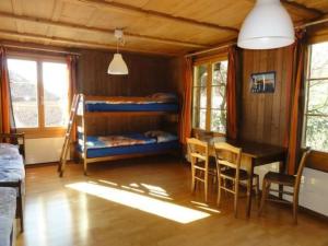 a room with bunk beds and a table and a dining room at Apartment Gurtendörfli by Interhome in Wabern