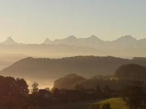 a misty view of a mountain range in the distance at Apartment Gurtendörfli by Interhome in Wabern