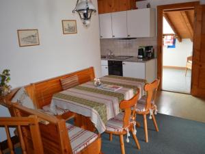 a kitchen with a table and two chairs and a kitchen with a table at Apartment Wohnung Rustique by Interhome in Chevenez