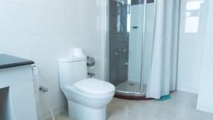 a white bathroom with a toilet and a shower at The Avenue Hotel & Suites in Chittagong