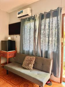 a couch in a living room with blue curtains at Seaside Blue Inn in San Vicente