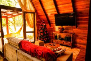 a living room with a couch and a christmas tree at Chalet Relaggio in Encantado