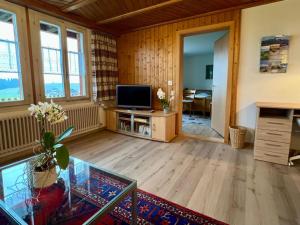 a living room with a television and a table at Apartment Chalet Hulda by Interhome in Heimenschwand