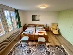 a bedroom with a bed and two chairs in it at Apartment Chalet Hulda by Interhome in Heimenschwand