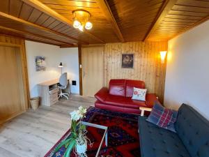 a living room with a red couch and a table at Apartment Chalet Hulda by Interhome in Heimenschwand