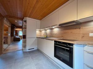 a kitchen with white cabinets and a stove top oven at Apartment Peak App- Morgins by Interhome in Morgins
