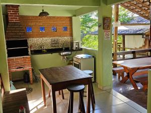 a kitchen with a table and a brick wall at Flats Alto das Pedras in Trindade