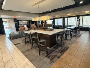 a lobby with tables and chairs in a building at Preston Suites by IHG in Montgomery
