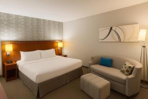 a hotel room with a bed and a chair at Preston Suites by IHG in Montgomery +26 photos