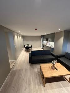 a living room with a black couch and a table at Skolegata 6B, 9404 Harstad in Harstad