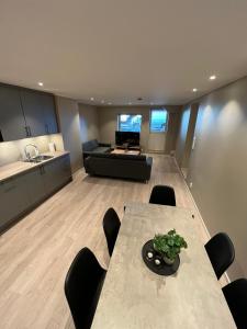 a dining room with a table and a couch at Skolegata 6B, 9404 Harstad in Harstad