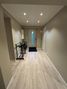 an empty hallway with a wooden floor and a window at Skolegata 6B, 9404 Harstad in Harstad