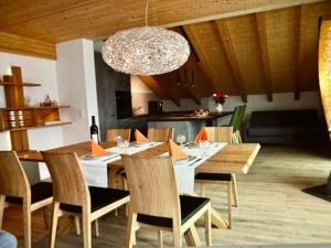 a dining room with a table and chairs and a chandelier at Apartment Panorama-Beatenberg by Interhome in Beatenberg