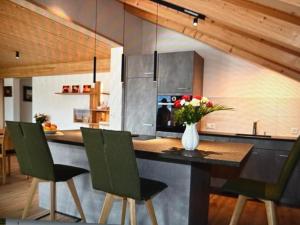 a kitchen with a counter with a vase of flowers on it at Apartment Panorama-Beatenberg by Interhome in Beatenberg +16 photos