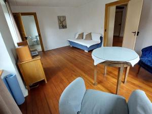 a living room with a table and a couch at Apartment Giselas Ruheplatz by Interhome in Liesberg