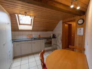a kitchen with a wooden table and a wooden ceiling at Apartment Muessache by Interhome in Dürrenroth