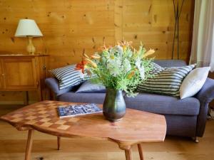 a vase of flowers on a table in a living room at Apartment Chalet Ried by Interhome in Diemtigen