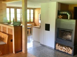 a living room with a fireplace in a kitchen at Apartment Chalet Ried by Interhome in Diemtigen