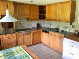 a kitchen with wooden cabinets and a sink at Apartment Chalet Ried by Interhome in Diemtigen