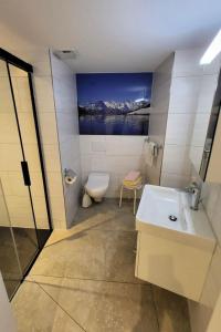 a bathroom with a sink and a toilet and a painting at Apartment Chalet Lilo Studio by Interhome in Beatenberg