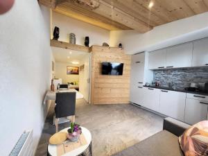 a kitchen and living room with white cabinets and a table at Apartment Chalet Lilo Studio by Interhome in Beatenberg