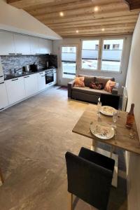 a kitchen and living room with a couch and a table at Apartment Chalet Lilo Studio by Interhome in Beatenberg