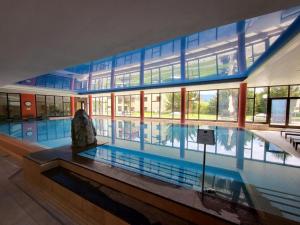 a large swimming pool in a building with a large building at Apartment Hotel Apartment by Interhome in Beatenberg