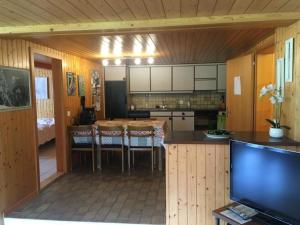 a kitchen with a table and chairs and a television at Apartment Frohmatt by Interhome in Adelboden +7 photos