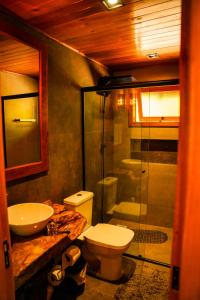 a bathroom with a toilet and a sink and a shower at Chalet Relaggio in Encantado +25 photos