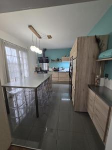 a kitchen with a island in the middle of a room at La maison bleue avec une grande piscine chauffée in Bozouls