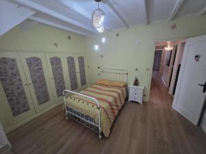 a bedroom with a bed with a striped blanket at La maison bleue avec une grande piscine chauffée in Bozouls