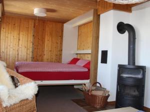 a bedroom with a bed and a wood stove at Apartment Huusli by Interhome in Axalp