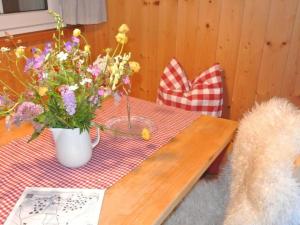 a table with a vase of flowers on it at Apartment Huusli by Interhome in Axalp