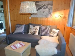 a living room with a couch with pillows and a table at Apartment Huusli by Interhome in Axalp +11 photos