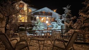 a house with a christmas tree and chairs in the snow at Republika Central Hotel & Resort in Abbottabad
