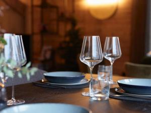 a table with three wine glasses and plates on it at Apartment My Chalet by Interhome in Meiringen +18 photos